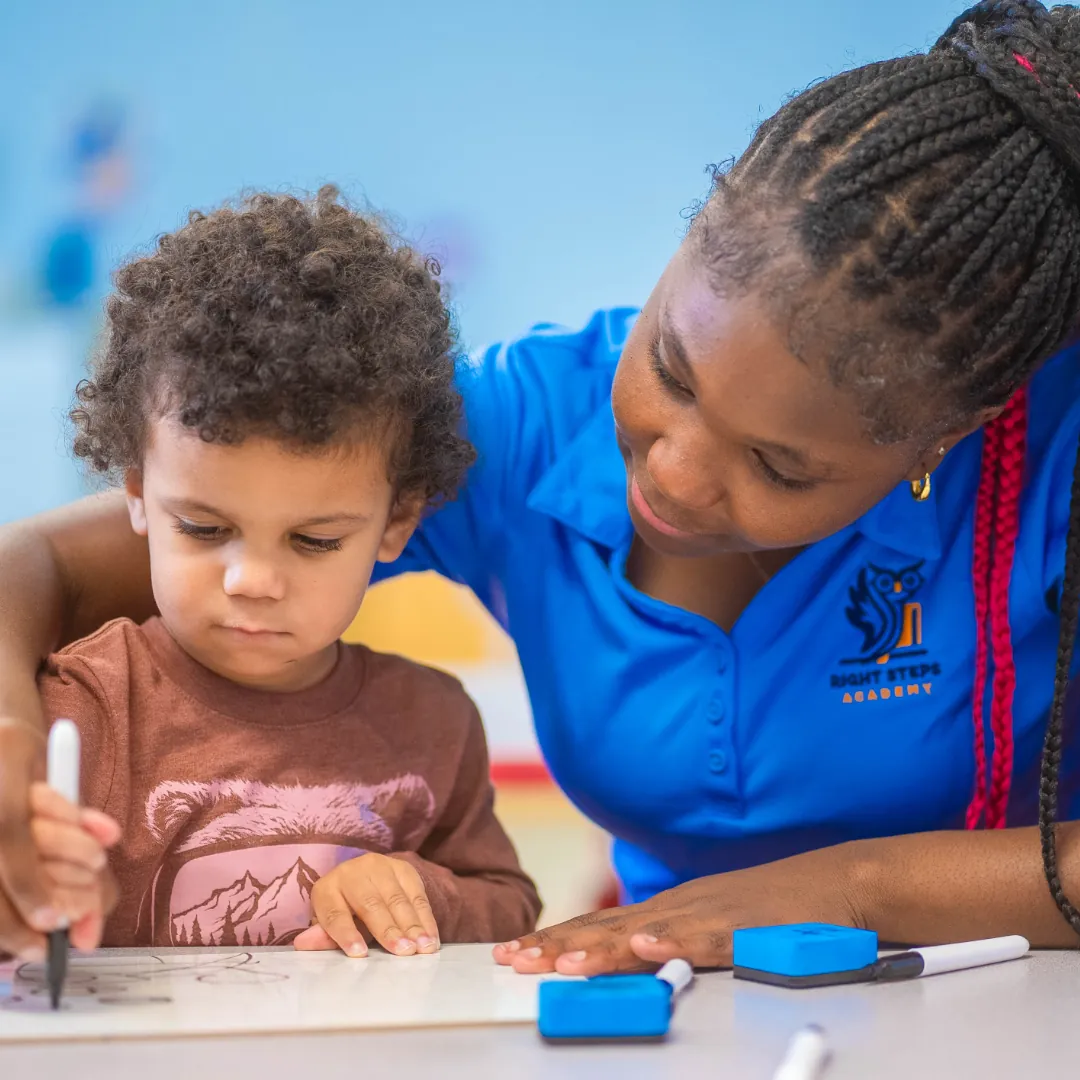 Teacher helping a child with a classroom learning activity