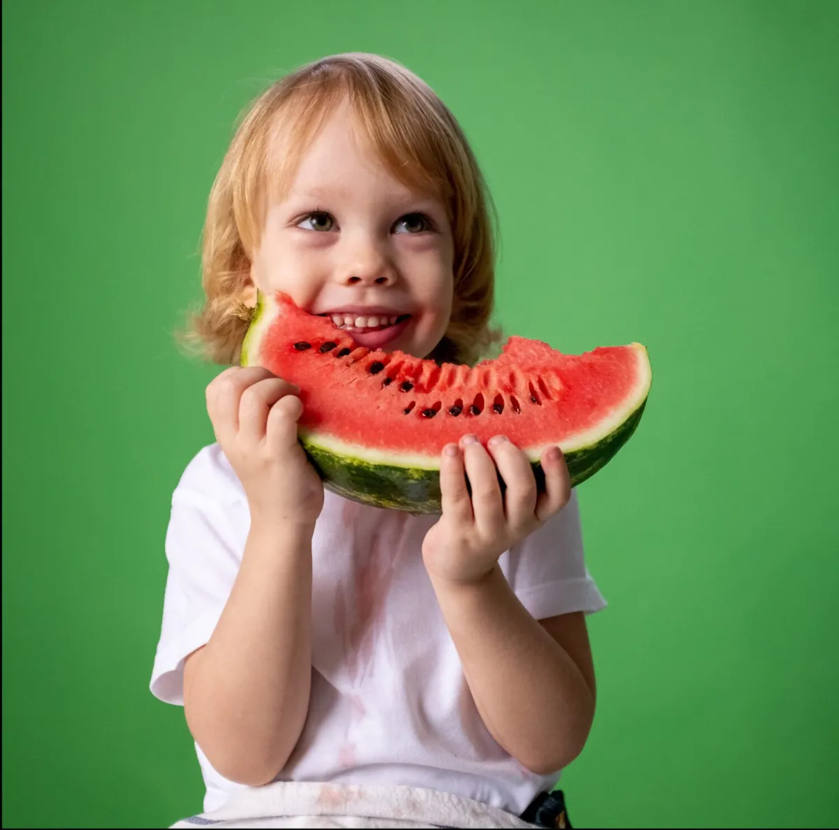 Child holding a slice of watermelon