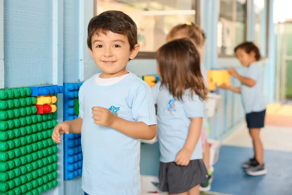 Child standing beside a classroom counting board