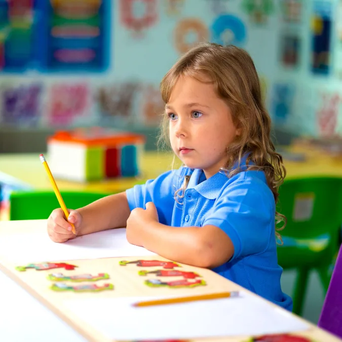 Child drawing at a classroom table