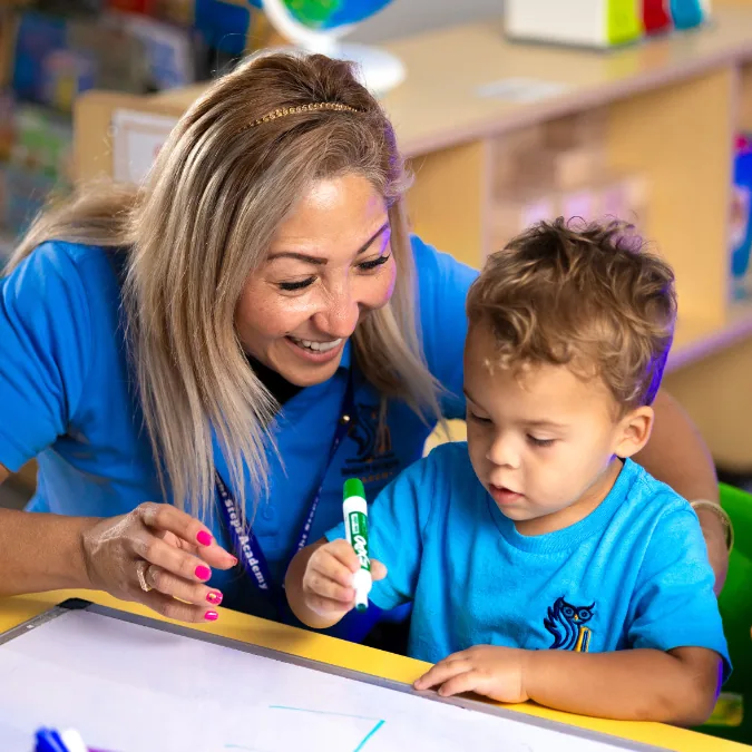 Teacher helping a child with a drawing activity