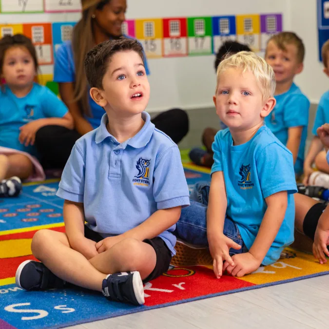 Children sitting together on a classroom alphabet rug